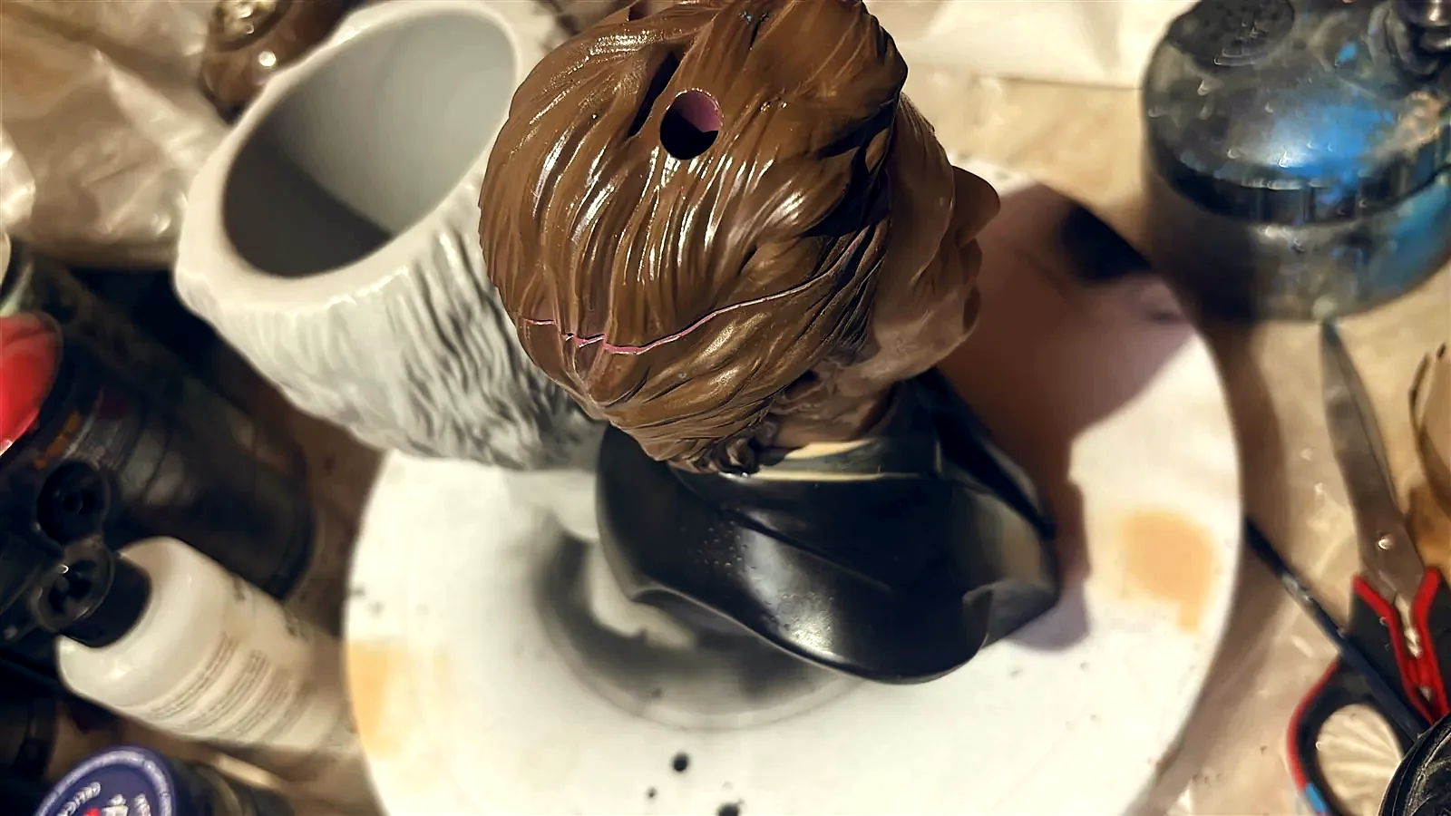 The Frankenstein cup rendered in 3D against black, seen face on, the stitches and bolts catching the light