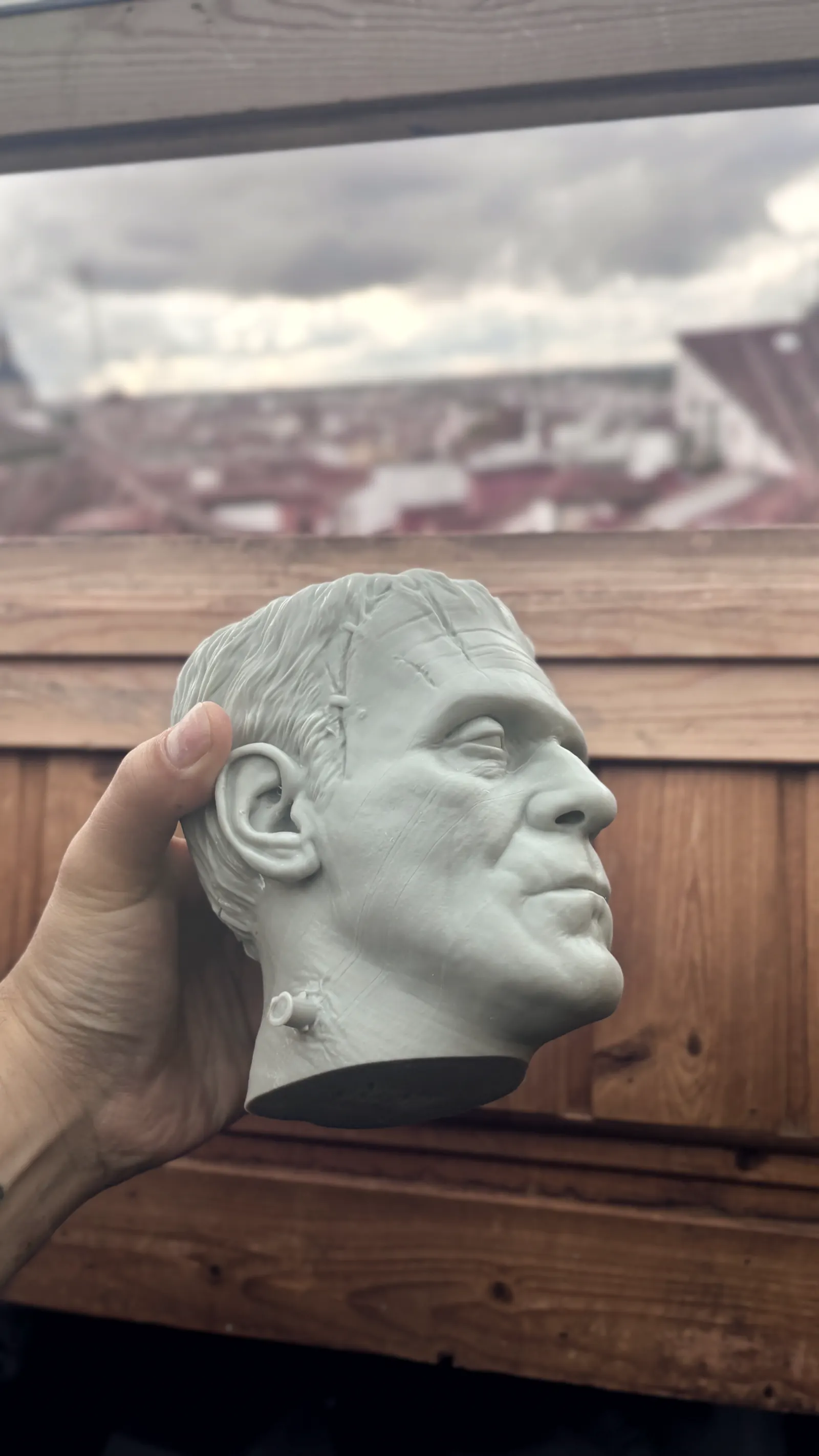 The Frankenstein cup rendered in 3D against black, seen face on, the stitches and bolts catching the light