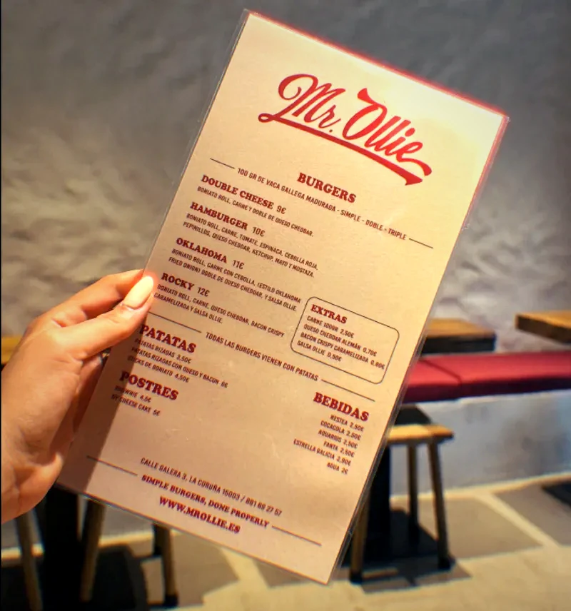 The Mr Ollie menu held in one hand, red script on cream paper